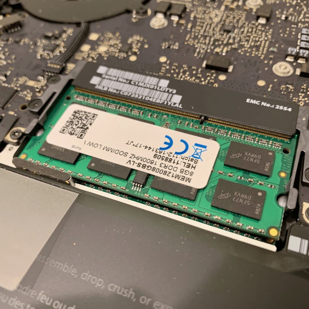 Close-up image of MacBook's internal components with focus on RAM modules, highlighting the upgrade service provided by iCore Dotcom.